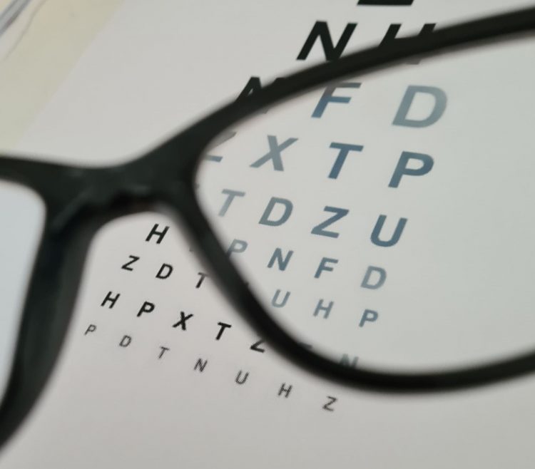 A photo of an eye chart through a pair of glasses.
